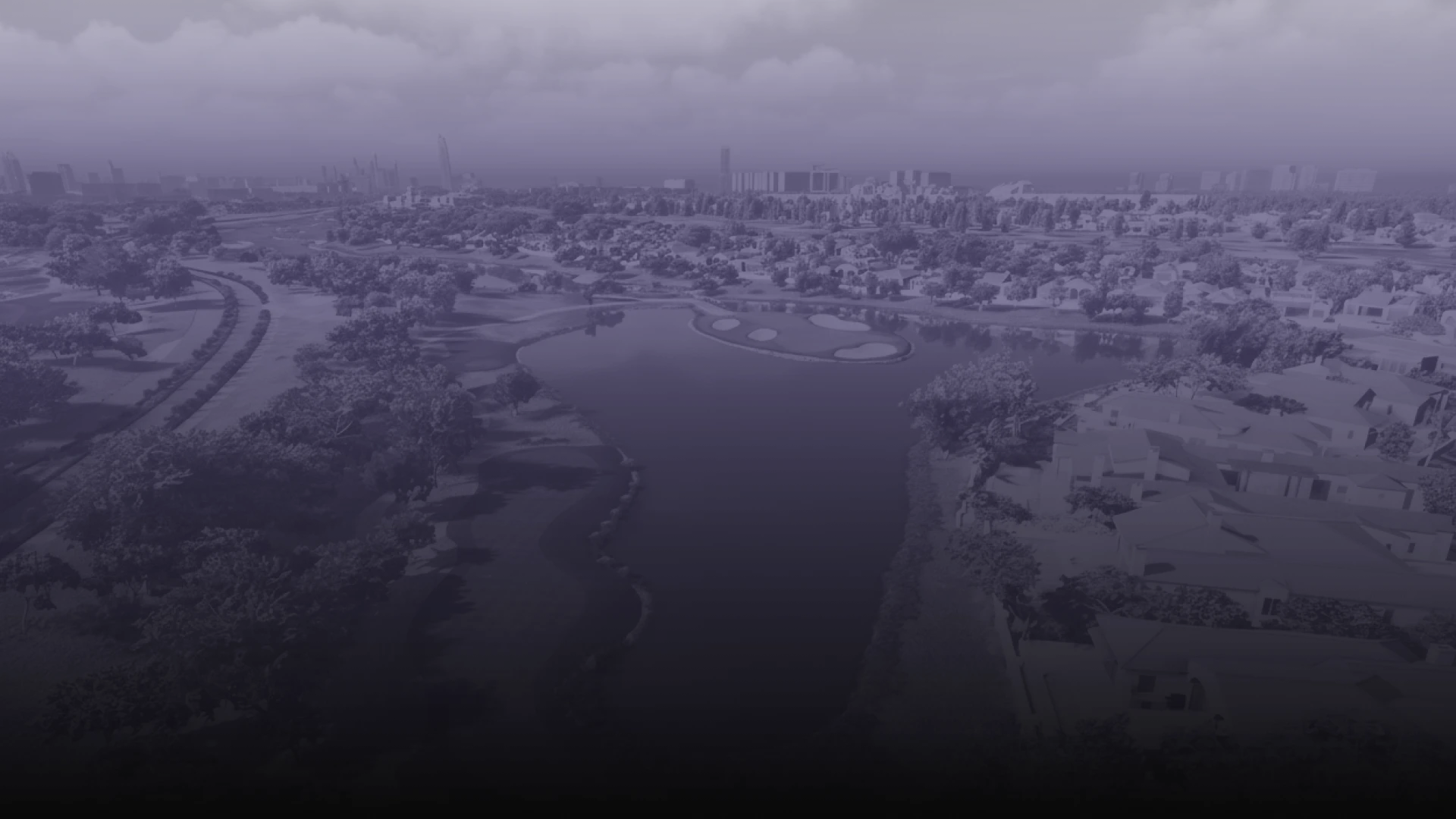 Aerial view of a cityscape with a river running through a residential area, surrounded by trees, under a cloudy sky.