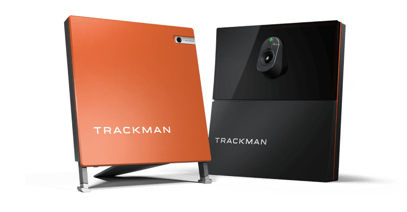 Two Trackman devices: one orange Trackman 4, and one black Trackman iO, both featuring the Trackman logo.